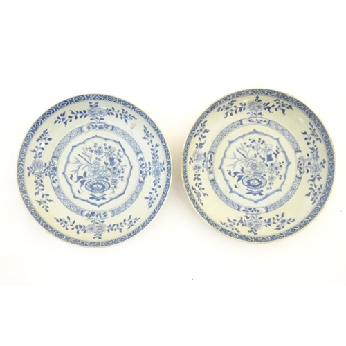 64 - A pair of Chinese blue and white plates with central vase with peonies and blossom, the border with ... 