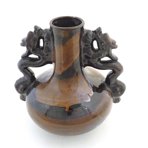 66 - A Oriental twin handled bottle vase with stylised dragon detail to handles. Approx. 10 1/4