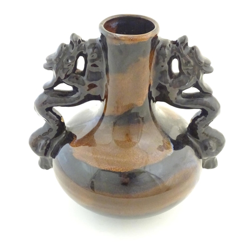 66 - A Oriental twin handled bottle vase with stylised dragon detail to handles. Approx. 10 1/4