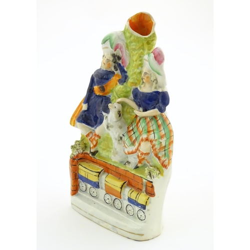 83 - A Victorian Staffordshire pottery bud vase with two children in highland dress with a dog between th... 