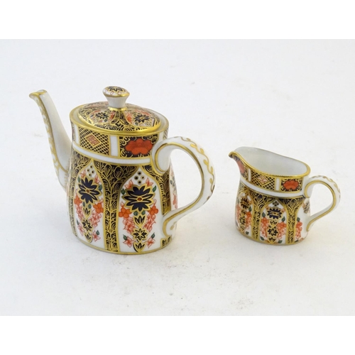 118 - Two Royal Crown Derby wares in the Imari palette, comprising a miniature teapot and milk jug. Marked... 