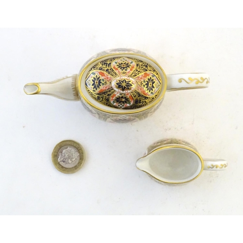 118 - Two Royal Crown Derby wares in the Imari palette, comprising a miniature teapot and milk jug. Marked... 