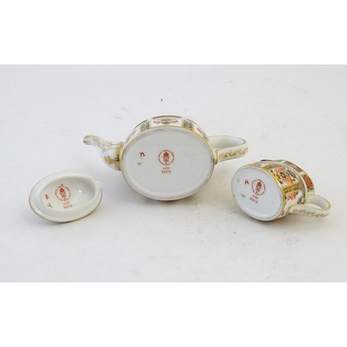 118 - Two Royal Crown Derby wares in the Imari palette, comprising a miniature teapot and milk jug. Marked... 