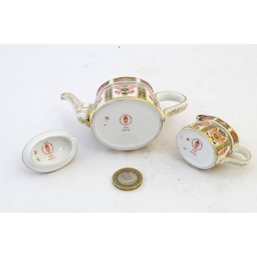 118 - Two Royal Crown Derby wares in the Imari palette, comprising a miniature teapot and milk jug. Marked... 