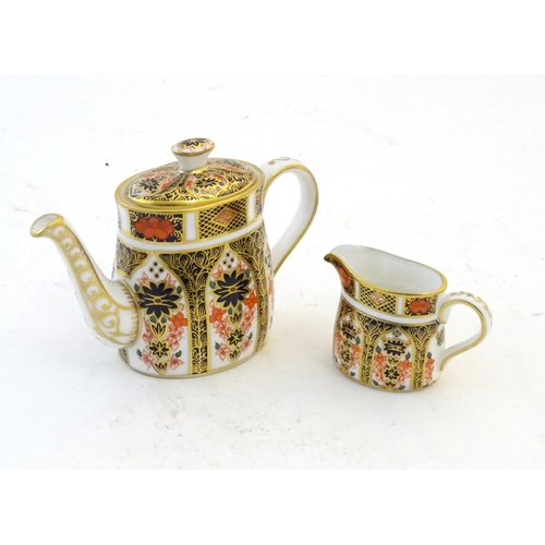 118 - Two Royal Crown Derby wares in the Imari palette, comprising a miniature teapot and milk jug. Marked... 