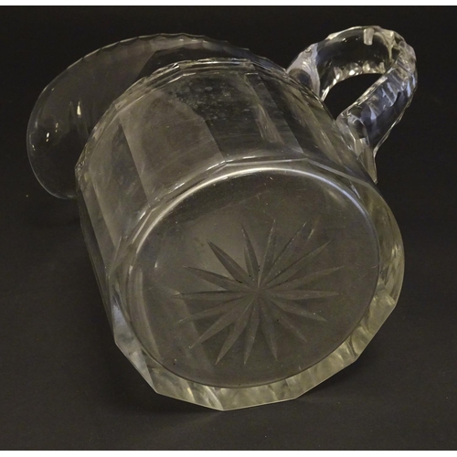 262 - A large 19thC glass water jug , decorated with fluted oval and roundel cuts, with starburst to the b... 