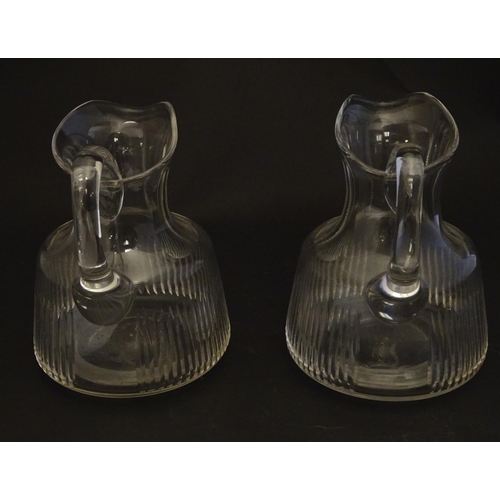 269 - A pair of late 19thC glass jugs, decorated with etched necks and bladed flute cuts, each 5 1/2