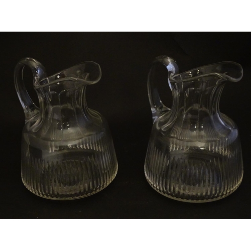 269 - A pair of late 19thC glass jugs, decorated with etched necks and bladed flute cuts, each 5 1/2