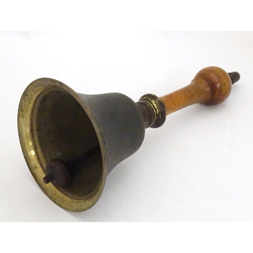 1170 - A 20thC hand bell with a turned wooden handle and acorn finial. Approx. 10 1/4