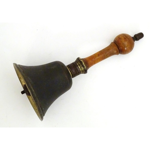 1170 - A 20thC hand bell with a turned wooden handle and acorn finial. Approx. 10 1/4