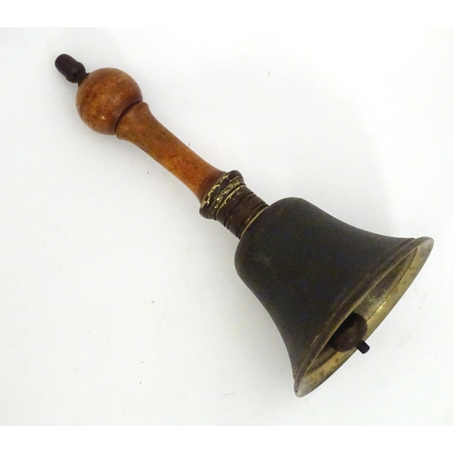 1170 - A 20thC hand bell with a turned wooden handle and acorn finial. Approx. 10 1/4