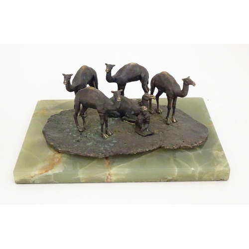 1225 - A late 19th / early 20thC bronze sculpture depicting camels and a seated Arabic man, mounted on an o... 