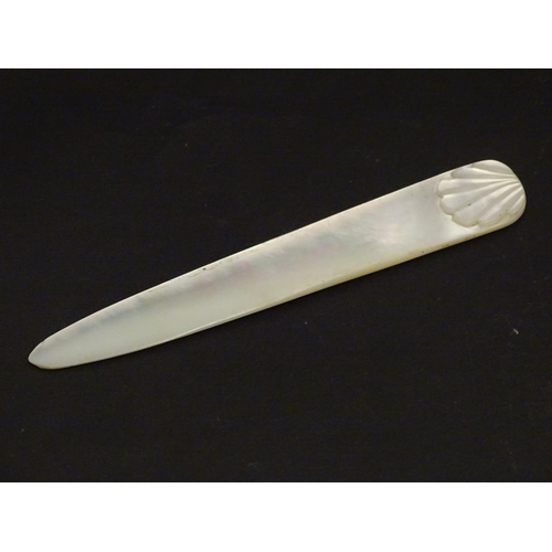 1229 - An early 20thC mother of pearl letter opener with shell detail. Approx. 4 1/4