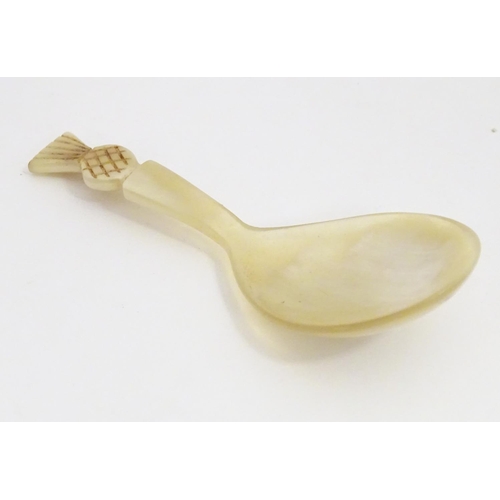 1237 - A 20thC horn caddy spoon with carved pineapple finial. Approx. 3 1/2