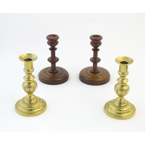 1335 - A pair of brass candlesticks with plunger action. Together with a pair of turned oak candlesticks. L... 