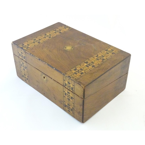 1338 - A 19thC walnut writing box with geometric marquetry / parquetry inlay. Approx. 6