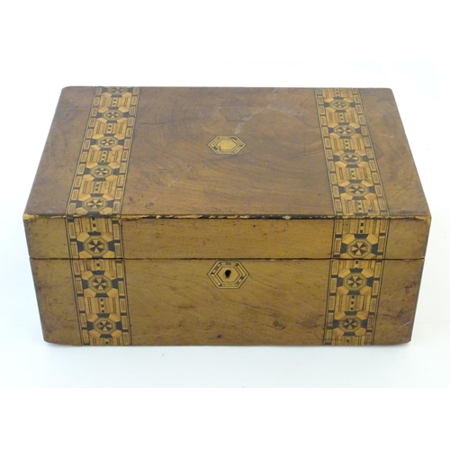 1338 - A 19thC walnut writing box with geometric marquetry / parquetry inlay. Approx. 6