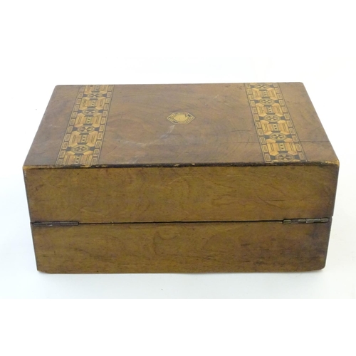 1338 - A 19thC walnut writing box with geometric marquetry / parquetry inlay. Approx. 6