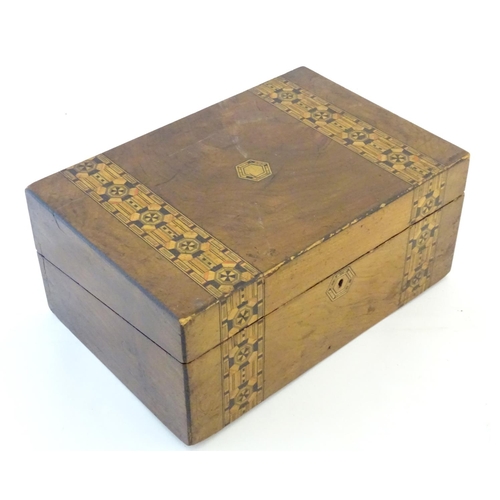 1338 - A 19thC walnut writing box with geometric marquetry / parquetry inlay. Approx. 6