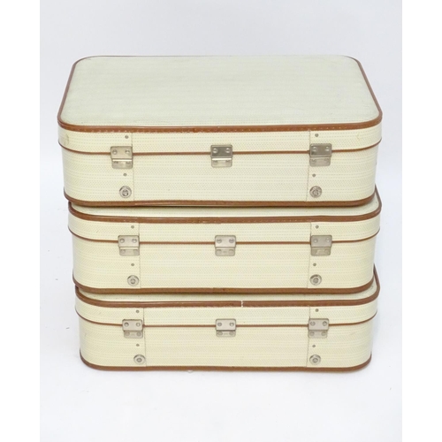 1341 - A mid 20thC set of three travelling suitcases by Cheney, London, in white with tan trim, each with d... 
