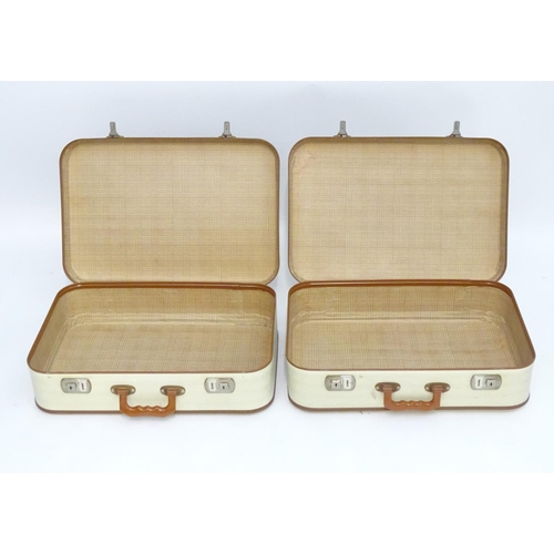 1341 - A mid 20thC set of three travelling suitcases by Cheney, London, in white with tan trim, each with d... 