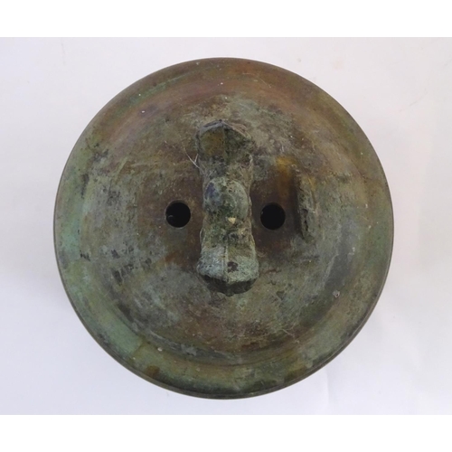 1345 - An Oriental cast temple bell the handle with twin mask detail. Approx. 19 1/4