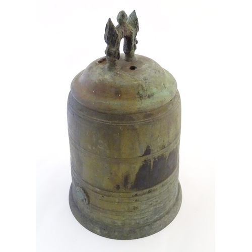 1345 - An Oriental cast temple bell the handle with twin mask detail. Approx. 19 1/4