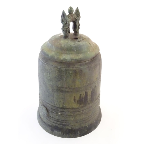 1345 - An Oriental cast temple bell the handle with twin mask detail. Approx. 19 1/4