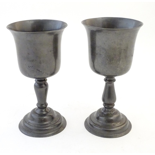 1360 - A matched pair of 19thC pewter pedestal cups / goblets. Largest approx. 9 1/4