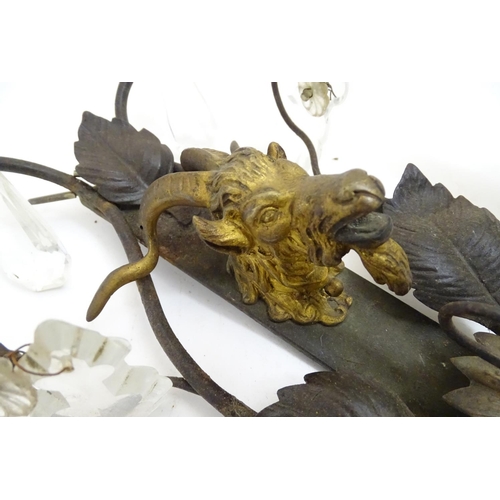 1364 - A pair of early 20thC Continental wall lights, decorated with gilt goat heads and patinated foliate ... 