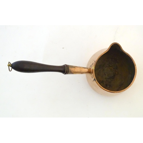 1366 - A 19thC copper saucepan with spout and turned wooden handle. Approx. 14 1/4