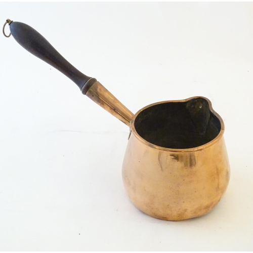 1366 - A 19thC copper saucepan with spout and turned wooden handle. Approx. 14 1/4