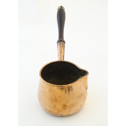 1366 - A 19thC copper saucepan with spout and turned wooden handle. Approx. 14 1/4