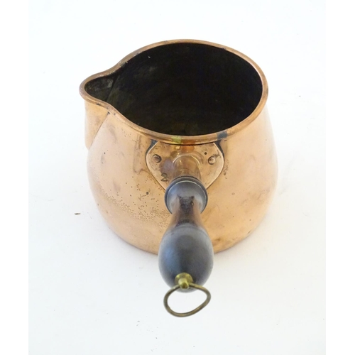 1366 - A 19thC copper saucepan with spout and turned wooden handle. Approx. 14 1/4