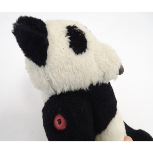 1486 - Toys: Two 20thC bears, comprising a panda bear with button jointed limbs, and a straw filled teddy b... 