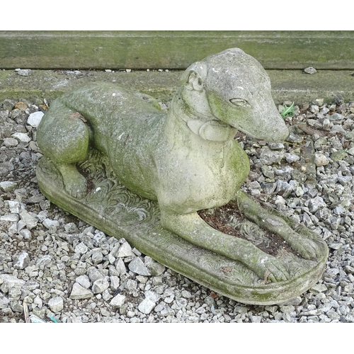 1599 - Garden & Architectural, Salvage: a 20thC reconstituted stone statue of a sejant long dog, approximat... 