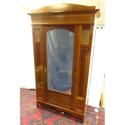 2093 - An early 20thC mahogany wardrobe with a bowed pediment above a moulded cornice and decoratively stru... 