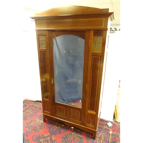 2093 - An early 20thC mahogany wardrobe with a bowed pediment above a moulded cornice and decoratively stru... 