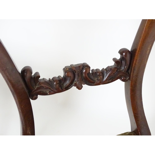 2094 - A pair of 19thC mahogany balloon back side chairs, with carved mid rails above shaped upholstered se... 