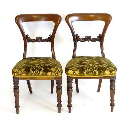 2094 - A pair of 19thC mahogany balloon back side chairs, with carved mid rails above shaped upholstered se... 