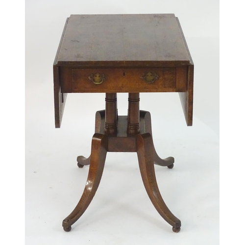 2097 - A Georgian oak Pembroke table with drop flaps, a pedestal base with four turned columns and the tabl... 