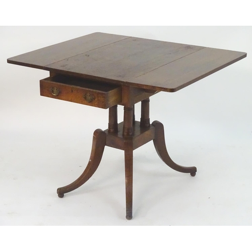 2097 - A Georgian oak Pembroke table with drop flaps, a pedestal base with four turned columns and the tabl... 