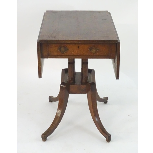 2097 - A Georgian oak Pembroke table with drop flaps, a pedestal base with four turned columns and the tabl... 