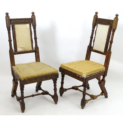 2098 - A pair of 19thC oak Gothic chairs, mounted by carved finials above incised frames with turned suppor... 