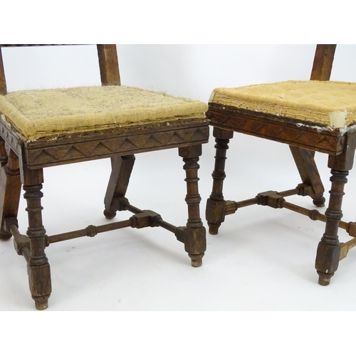 2098 - A pair of 19thC oak Gothic chairs, mounted by carved finials above incised frames with turned suppor... 