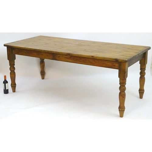 2206 - A mid / late 20thC pine farmhouse table stood on four large turned legs. 78