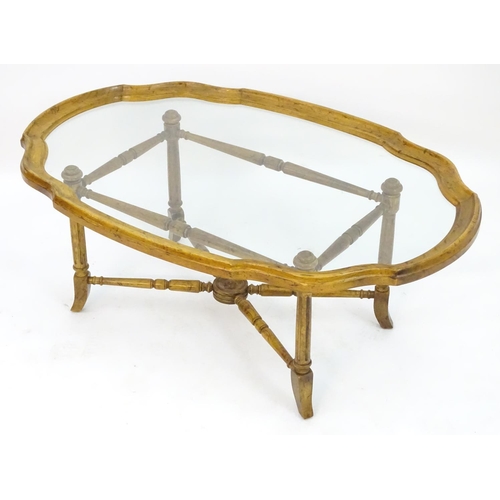 2214 - A mid to late 20thC occasional table, the base with x stretcher supporting a framed glass top, 44 1/... 