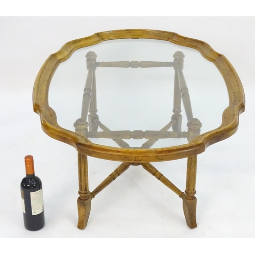 2214 - A mid to late 20thC occasional table, the base with x stretcher supporting a framed glass top, 44 1/... 