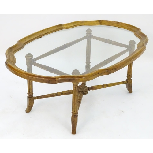 2214 - A mid to late 20thC occasional table, the base with x stretcher supporting a framed glass top, 44 1/... 