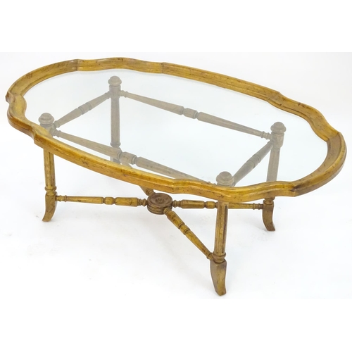 2214 - A mid to late 20thC occasional table, the base with x stretcher supporting a framed glass top, 44 1/... 